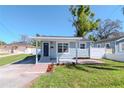 Charming single-story home featuring a cozy covered porch, brick walkway, and well-maintained lawn at 7015 N Dakota Ave, Tampa, FL 33604
