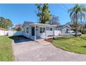Charming single-story home with covered porch, brick accents, fenced yard, and a paved driveway at 7015 N Dakota Ave, Tampa, FL 33604