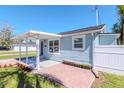Cozy single-story home with covered porch, flower boxes, and a white picket fence at 7015 N Dakota Ave, Tampa, FL 33604