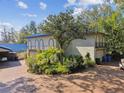 Exterior of home with arched balconies, a circular driveway, and mature trees for added privacy at 8510 Lays Cove Pl, Odessa, FL 33556