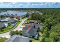 Aerial view of a single-Gathering home near a lake and surrounded by lush greenery and neighboring houses at 12906 Tar Flower Dr, Tampa, FL 33626