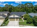 Beautiful single-Gathering home with a well-manicured lawn, two-car garage, and lush green trees in the background at 12906 Tar Flower Dr, Tampa, FL 33626