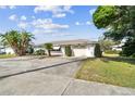 Single story home with an attached two car garage and mature landscaping at 1730 Sunset Point Rd, Clearwater, FL 33755