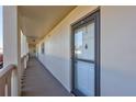 Condo entrance with white front door, hallway, neutral paint, and exterior corridor at 19029 Us Highway 19 N # 8-15, Clearwater, FL 33764