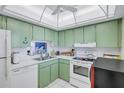 Functional kitchen with white tile floors, green cabinets, and ample counter space at 19029 Us Highway 19 N # 8-15, Clearwater, FL 33764