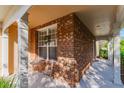 Inviting front porch with brick siding, seating area, and covered entry at 4654 Pond Ridge Dr, Riverview, FL 33578