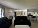 Open-concept living room with dark sofas, neutral walls, and tile floors, creating a welcoming and spacious atmosphere at 5434 Saddlebrook Way # 3, Wesley Chapel, FL 33543