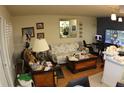 Bright living room with a sofa, mirror reflecting plants, and a TV creates an inviting atmosphere at 6000 20Th N St # 141, St Petersburg, FL 33714