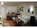 A living room features a patterned sofa, plants in a mirror, and natural light, creating a comfy, inviting space at 6000 20Th N St # 141, St Petersburg, FL 33714