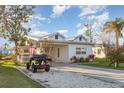 Lovely exterior view of a home with a well-kept lawn, driveway, and a golf cart parked nearby at 607 Manatee Ave, Ellenton, FL 34222