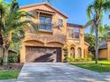 Charming two-story stucco home with a two-car garage, balcony, arched windows, and lush palm trees at 8264 Dunham Station Dr, Tampa, FL 33647