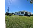Exterior shot of house with well-maintained lawn and various windows and outdoor features at 10063 40Th N St # 3, Pinellas Park, FL 33782