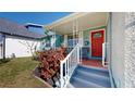 Inviting front porch with decorative railing, steps, and vibrant red door at 1011 W Charter St, Tampa, FL 33602