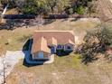 Aerial view of a single-story house, showing the roof, driveway, and surrounding landscape at 11054 Liberto Rd, Weeki Wachee, FL 34614