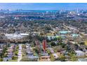 Aerial view of a residential area with tree coverage and distant skyline, arrow denotes property at 1579 Magnolia Dr, Clearwater, FL 33756
