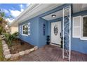 Inviting covered porch with charming decor and well-manicured landscaping by the front door at 1579 Magnolia Dr, Clearwater, FL 33756