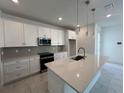 Bright kitchen with white cabinetry, stainless steel appliances, quartz countertops, and sleek modern design at 31857 Anchor Point Dr, Wesley Chapel, FL 33545