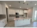 Modern kitchen featuring white cabinets, quartz countertops, stainless steel appliances, and pendant lighting at 31857 Anchor Point Dr, Wesley Chapel, FL 33545