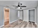 This spacious bedroom features a ceiling fan, closet, and gray wood flooring at 39809 Pretty Pond Rd, Zephyrhills, FL 33540