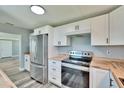 Modern kitchen showcases stainless steel appliances, sleek white cabinets, and butcher block countertops at 39809 Pretty Pond Rd, Zephyrhills, FL 33540