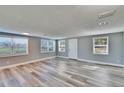 Bright, open living room features new gray wood flooring and abundant natural light through multiple windows at 39809 Pretty Pond Rd, Zephyrhills, FL 33540