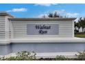 Sign for Walnut Run community featuring manicured bushes and clean, white entry features at 10328 Celtic Ash Dr, Ruskin, FL 33573