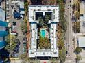 Aerial shot of building's unique layout with pool and courtyard, surrounded by parking and city streets at 105 4Th Ne Ave # 418, St Petersburg, FL 33701