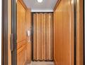 Accessible elevator with wood paneled walls providing easy access between floors of the home at 11555 Gulf Blvd Blvd # 115, Treasure Island, FL 33706