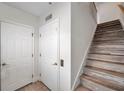 Bright entryway featuring wood stairs, white walls, and doors providing a clean and welcoming atmosphere at 11555 Gulf Blvd Blvd # 115, Treasure Island, FL 33706