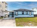 Charming single-story home featuring a carport, light blue exterior, and well-maintained lawn at 14050 W Parsley Dr, Madeira Beach, FL 33708