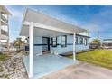 Welcoming exterior featuring a carport, a bright blue facade, and well-kept landscaping at 14050 W Parsley Dr, Madeira Beach, FL 33708