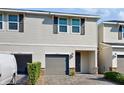 Charming two-story townhouse with gray garage door, stone accents, and manicured landscaping at 15033 Abby Birch Pl, Tampa, FL 33613