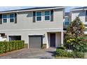 Charming two-story townhouse with gray garage door, stone accents, and manicured landscaping at 15033 Abby Birch Pl, Tampa, FL 33613