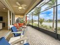 Inviting screened patio featuring comfortable seating with a fan and lovely water view at 15434 Santa Pola Dr, Wimauma, FL 33598