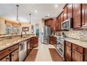 Spacious kitchen featuring dark wood cabinetry, stainless steel appliances, and granite countertops at 29500 Blackwolf Run Loop, San Antonio, FL 33576