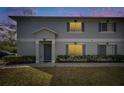 Charming two-story townhouse featuring a well-maintained lawn and gray shutters at dusk at 4049 Dolphin Dr, Tampa, FL 33617