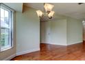 Bright dining area featuring hardwood floors, a modern chandelier, and natural light at 4908 Lynchburg Ct, New Port Richey, FL 34655