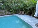 Inviting backyard pool with a lounge chairs, surrounded by lush tropical landscaping at 4912 W Dryad St, Tampa, FL 33629