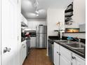 Compact kitchen includes stainless steel appliances and black countertops at 501 Knights Run Ave # 1310, Tampa, FL 33602