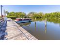 Close-up of the private boat dock, with a boat docked, and calm water reflecting the scenery at 504 S Florida Ave # 225, Tarpon Springs, FL 34689