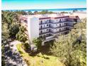 Beautiful condo building with multiple floors, balconies, and lush tropical landscaping at 504 S Florida Ave # 225, Tarpon Springs, FL 34689