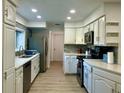 Bright kitchen featuring white cabinets, stainless steel appliances, and modern countertops at 5144 Pine Tree Ln, Wesley Chapel, FL 33543