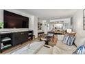 Stylish living room open to kitchen and dining room, with hardwood flooring and large screen TV at 620 Edgewater Dr # 204, Dunedin, FL 34698