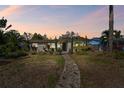Charming single-story home featuring a stone walkway, mature landscaping, and a neatly maintained lawn at 921 39Th Ne Ave, St Petersburg, FL 33703