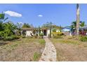 Charming single-story home featuring a stone walkway, mature landscaping, and a neatly maintained lawn at 921 39Th Ne Ave, St Petersburg, FL 33703