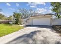 View of the house, concrete driveway, and two-car garage with a lawn in the foreground at 1008 Samy Dr, Tampa, FL 33613