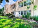 Two-story condominium with exterior stucco walls, lots of windows, and fresh green grass at 110 Aspen Cir, Seminole, FL 33777