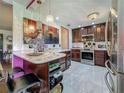 Charming kitchen featuring dark wood cabinets, marble tile flooring, pendant lighting, and stainless steel appliances at 110 Aspen Cir, Seminole, FL 33777