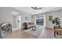 Bright living area with hardwood flooring, a modern ceiling fan, and access to the outdoor balcony at 1142 84Th N Ter # C, St Petersburg, FL 33702
