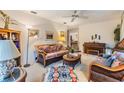 Comfortable living room featuring wicker furnishings, neutral carpeting, and a ceiling fan at 1421 Monte Carlo Dr, Clearwater, FL 33764